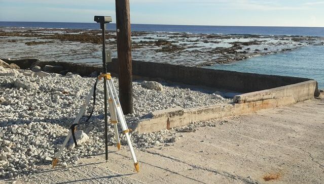 Récepteur GNSS Emlid Reach RS2 monté sur trépied lors d'un relevé au bord du lagon